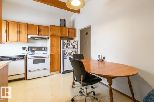 Kitchen featuring wood-finish cabinetry, white appliances, and a tiled backsplash - 13437 118 Street, Edmonton, AB - Indoor Photo Showing Kitchen