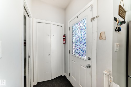 Entryway featuring a white door with a stained glass window, a closet with bi-fold doors, and light gray walls - 8204 224 Nw, Edmonton, AB - Indoor Photo Showing Other Room