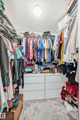Walk-in closet featuring built-in white wire shelving, hanging rods, and a white six-drawer dresser - 8204 224 Nw, Edmonton, AB - Indoor With Storage