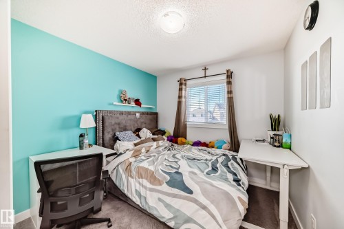 The room features a window with blinds and curtains, a light-colored carpet, and a light fixture on the ceiling - 8204 224 Nw, Edmonton, AB - Indoor Photo Showing Bedroom