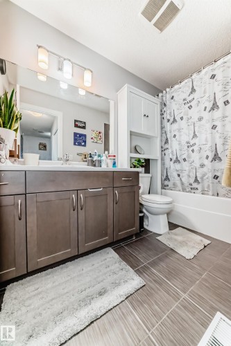 Bathroom featuring a spacious vanity with two sinks, a wall-mounted mirror, and overhead lighting - 8204 224 Nw, Edmonton, AB - Indoor Photo Showing Bathroom