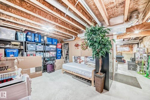 The property features an unfinished basement with exposed wooden joists and ductwork, providing a versatile space - 8204 224 Nw, Edmonton, AB - Indoor Photo Showing Basement