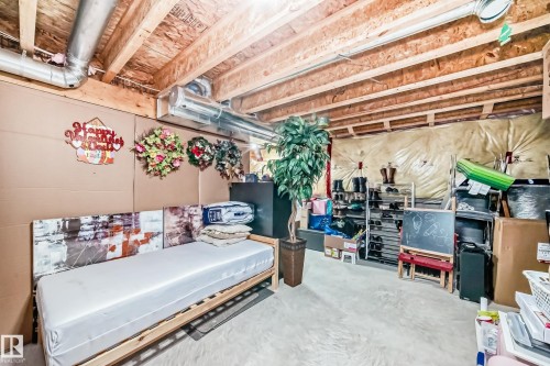 The property features a utility room with an exposed wooden beam ceiling and visible ductwork - 8204 224 Nw, Edmonton, AB - Indoor Photo Showing Basement
