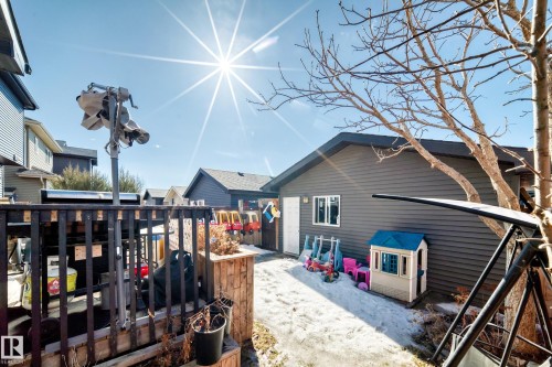 The property features a dark gray exterior with white trim around the window, and a white door, set against a clear blue sky - 8204 224 Nw, Edmonton, AB - Outdoor