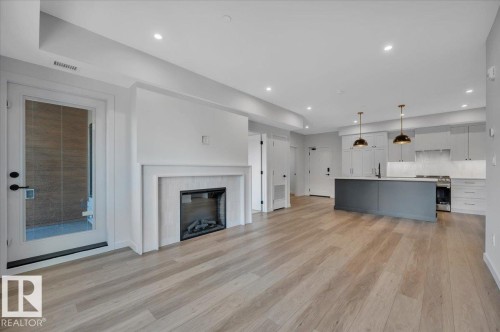 SPACIOUS LIVING AREA WITH ELECTRIC FIREPLACE - 322 7459 May Common Nw, Edmonton, AB - Indoor With Fireplace
