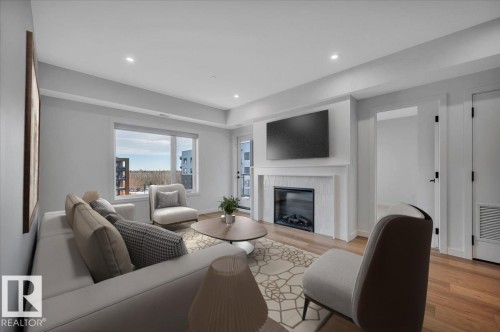 VIRTUALLY STAGED - 322 7459 May Common Nw, Edmonton, AB - Indoor Photo Showing Living Room With Fireplace