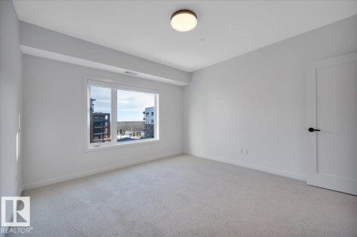 WITH VIEWS OF THE RAVINE - 322 7459 May Common Nw, Edmonton, AB - Indoor Photo Showing Other Room