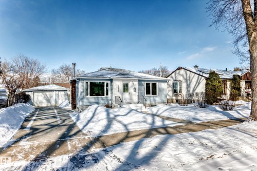 View of front of home with an outbuilding, a detached garage, and driveway - 3634 113 Avenue, Edmonton, AB - Outdoor