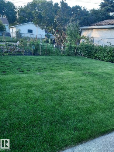 The property features a well-maintained lawn and a garden area with various plantings - 3634 113 Avenue, Edmonton, AB - Outdoor