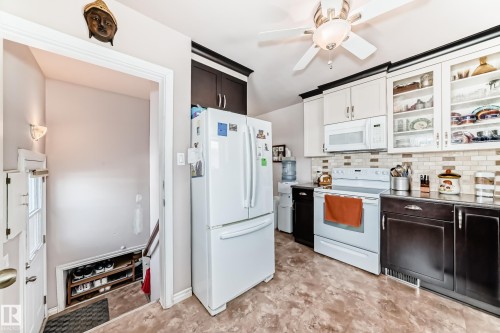 Kitchen with glass insert cabinets, white appliances, a ceiling fan, light countertops, and backsplash - 3634 113 Avenue, Edmonton, AB - Indoor Photo Showing Kitchen