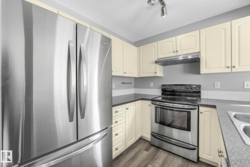 The kitchen features stainless steel appliances, including a side-by-side refrigerator and an oven with a range hood - 123 230 Edwards Drive, Edmonton, AB - Indoor Photo Showing Kitchen