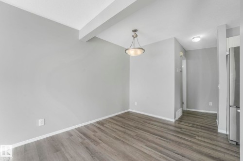 Bright room featuring gray walls, light wood flooring, and a ceiling-mounted light fixture - 123 230 Edwards Drive, Edmonton, AB - Indoor Photo Showing Other Room