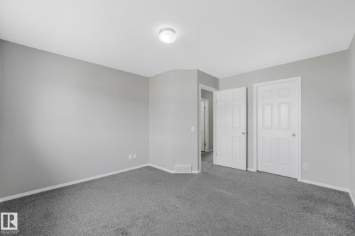 This room features neutral gray walls, gray carpeting, and a ceiling light fixture - 123 230 Edwards Drive, Edmonton, AB - Indoor Photo Showing Other Room