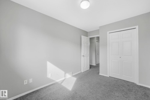 This room features grey carpeting, light grey walls, and white trim - 123 230 Edwards Drive, Edmonton, AB - Indoor