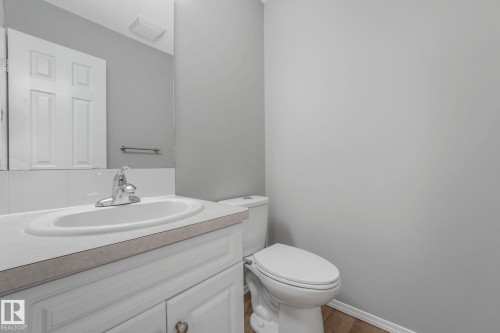 Bathroom featuring a white vanity with a built-in sink, a toilet, and light gray walls - 123 230 Edwards Drive, Edmonton, AB - Indoor Photo Showing Bathroom