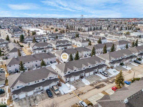 Aerial view showcasing the property within a residential setting, featuring townhomes with attached garages and surrounding greenery - 123 230 Edwards Drive, Edmonton, AB - Outdoor With View