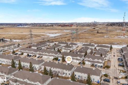 Aerial view of a residential complex featuring rows of townhomes with grey roofs - 123 230 Edwards Drive, Edmonton, AB - Outdoor With View
