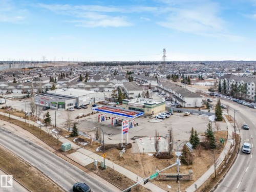 The property is surrounded by established residential areas and commercial buildings, with a prominent road running alongside - 123 230 Edwards Drive, Edmonton, AB - Outdoor With View