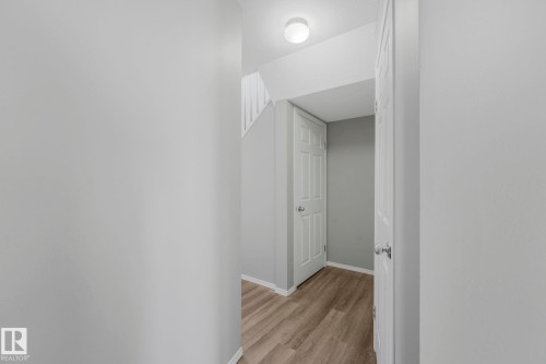 Entryway featuring light wood-look flooring and white paneled doors - 123 230 Edwards Drive, Edmonton, AB - Indoor Photo Showing Other Room