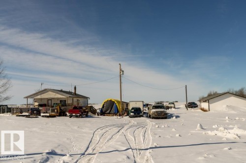 The property features a single-story residence with a covered porch and an exterior finished in a light color - 112, 57004 Range Rd 105, Rural St. Paul County, AB - Outdoor