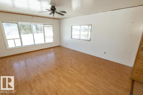 This spacious room features hardwood flooring, white walls, and a ceiling fan - 112, 57004 Range Rd 105, Rural St. Paul County, AB - Indoor Photo Showing Other Room