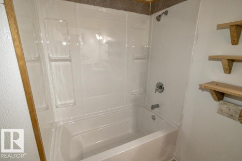 Bathroom featuring a clean white shower and bathtub combination with a chrome shower head and faucet - 112, 57004 Range Rd 105, Rural St. Paul County, AB - Indoor Photo Showing Bathroom