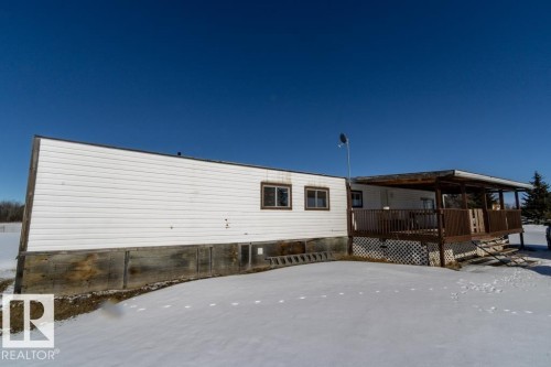 The property features white siding and a brown wooden deck with a partial covering - 112, 57004 Range Rd 105, Rural St. Paul County, AB - Outdoor With Exterior