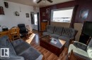 Living area featuring wood flooring, a ceiling fan, and a window with an exterior view - 112, 57004 Range Rd 105, Rural St. Paul County, AB  - Indoor Photo Showing Living Room 