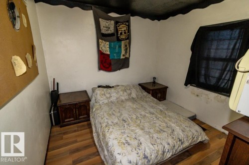 This room features wood-style flooring and a window - 112, 57004 Range Rd 105, Rural St. Paul County, AB - Indoor Photo Showing Bedroom