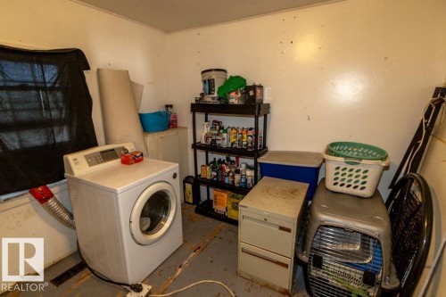 The property includes a utility area with a washing machine and storage shelving - 112, 57004 Range Rd 105, Rural St. Paul County, AB - Indoor Photo Showing Laundry Room