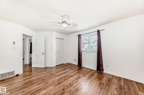 This room features hardwood flooring, white walls, and a window with a view of trees - 1832 42 Street, Edmonton, AB - Indoor Photo Showing Other Room