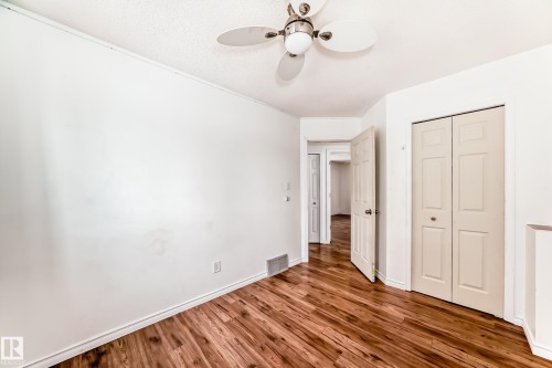 This space features hardwood flooring and light-colored walls, complemented by a ceiling fan - 1832 42 Street, Edmonton, AB - Indoor Photo Showing Other Room