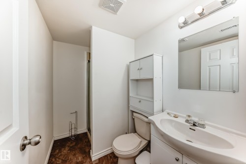 The bathroom features a vanity with an integrated sink, a mirror, and overhead lighting - 1832 42 Street, Edmonton, AB - Indoor Photo Showing Bathroom