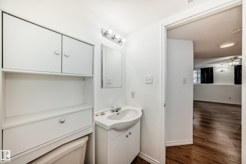 Bathroom featuring a white vanity with an integrated sink, a wall-mounted medicine cabinet, and overhead storage cabinetry - 1832 42 Street, Edmonton, AB - Indoor Photo Showing Bathroom