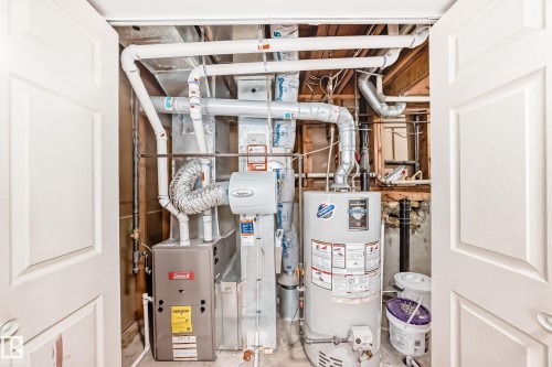 Utility area featuring a water heater, furnace, and exposed ceiling joists - 1832 42 Street, Edmonton, AB - Indoor Photo Showing Basement