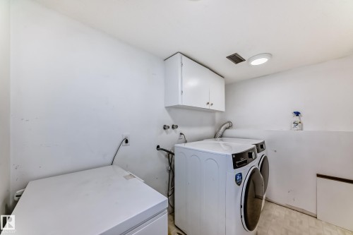 Dedicated utility space featuring laundry appliances, upper cabinetry, and a freezer - 1832 42 Street, Edmonton, AB - Indoor Photo Showing Laundry Room
