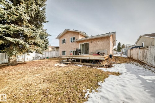 The property features a spacious backyard with a large deck, mature trees, and a privacy fence - 1832 42 Street, Edmonton, AB - Outdoor