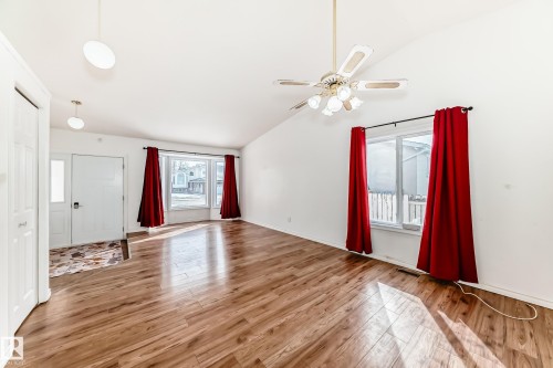 Spacious living area featuring vaulted ceilings, wood flooring, and large windows with natural light - 1832 42 Street, Edmonton, AB - Indoor Photo Showing Other Room
