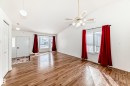Spacious living area featuring vaulted ceilings, wood flooring, and large windows with natural light - 1832 42 Street, Edmonton, AB  - Indoor Photo Showing Other Room 