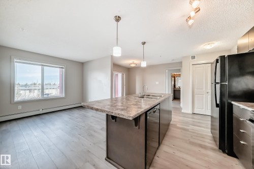 The kitchen features a functional island with a double basin sink and a dishwasher - 332 344 Windermere Road, Edmonton, AB - Indoor Photo Showing Kitchen
