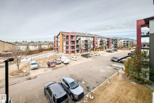 The property features a multi-story building with balconies, surrounded by a paved parking area and landscaped grounds - 332 344 Windermere Road, Edmonton, AB - Outdoor