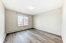 This room features light-colored walls and a window providing a view of buildings - 