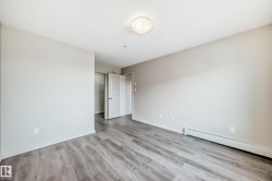 This room features light grey walls, grey plank flooring, and a ceiling light fixture - 