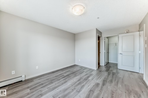 This room features light grey walls and light wood-look flooring - 332 344 Windermere Road, Edmonton, AB - Indoor Photo Showing Other Room