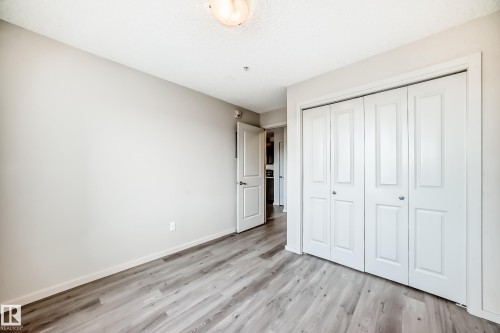 This room features light-colored walls and modern wood-look flooring - 332 344 Windermere Road, Edmonton, AB - Indoor Photo Showing Other Room