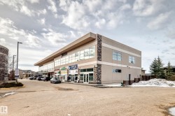 The commercial building features a modern design with large windows and stone accent panels - 