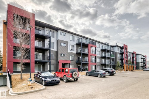 The property features a multi-story building with a modern facade, incorporating grey, red, and orange exterior panels - 332 344 Windermere Road, Edmonton, AB - Outdoor With Balcony With Facade