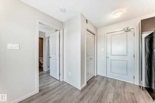 The property features light-toned flooring, white walls, and white doors, creating a bright and airy atmosphere - 332 344 Windermere Road, Edmonton, AB - Indoor Photo Showing Other Room