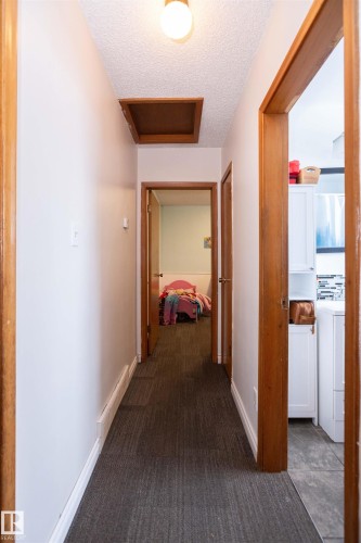 Hallway with carpet flooring, white walls, and wood trim - 4420 56 Avenue, Barrhead, AB - Indoor Photo Showing Other Room