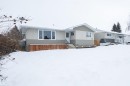 The property features a light-colored stucco exterior with contrasting siding, a prominent front window, and a white front door accessible by exterior steps - 4420 56 Avenue, Barrhead, AB  - Outdoor 